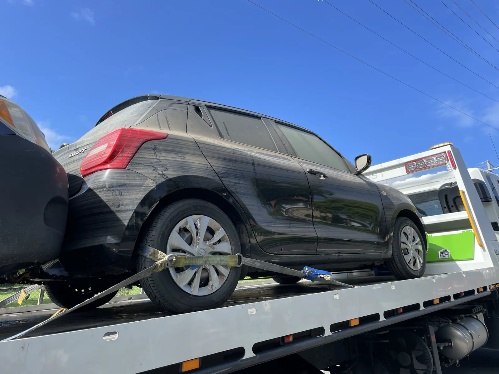 Black hatchback loaded on a truck for cash for cars removal