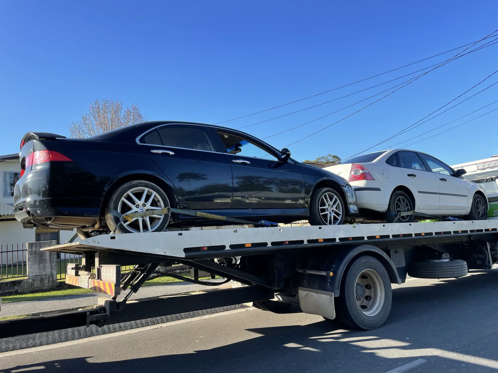 Black sedan loaded on a tow truck in Queensland