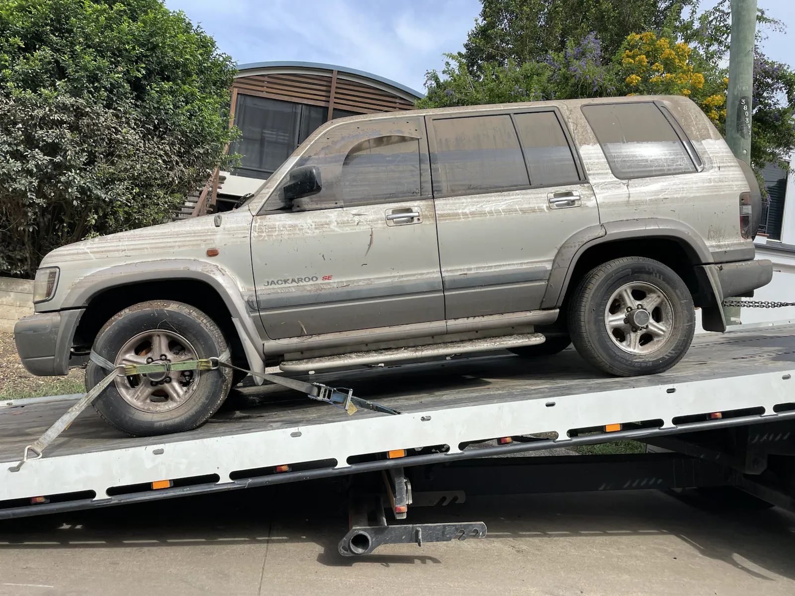 Silver four wheel drive loaded on a tilt tray in Queensland