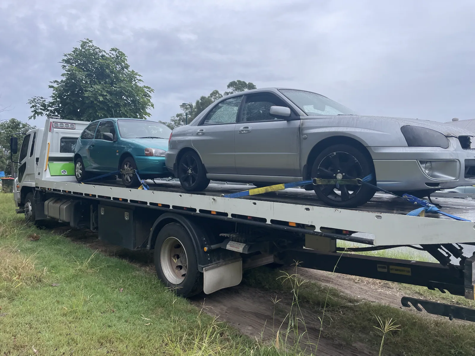 Silver ute loaded for removal on a tow truck